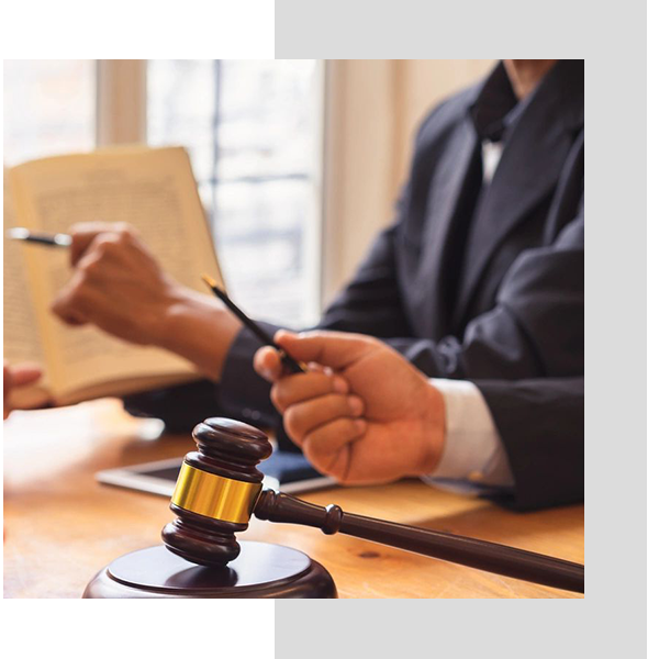 A judge is holding his pen while sitting at the table.